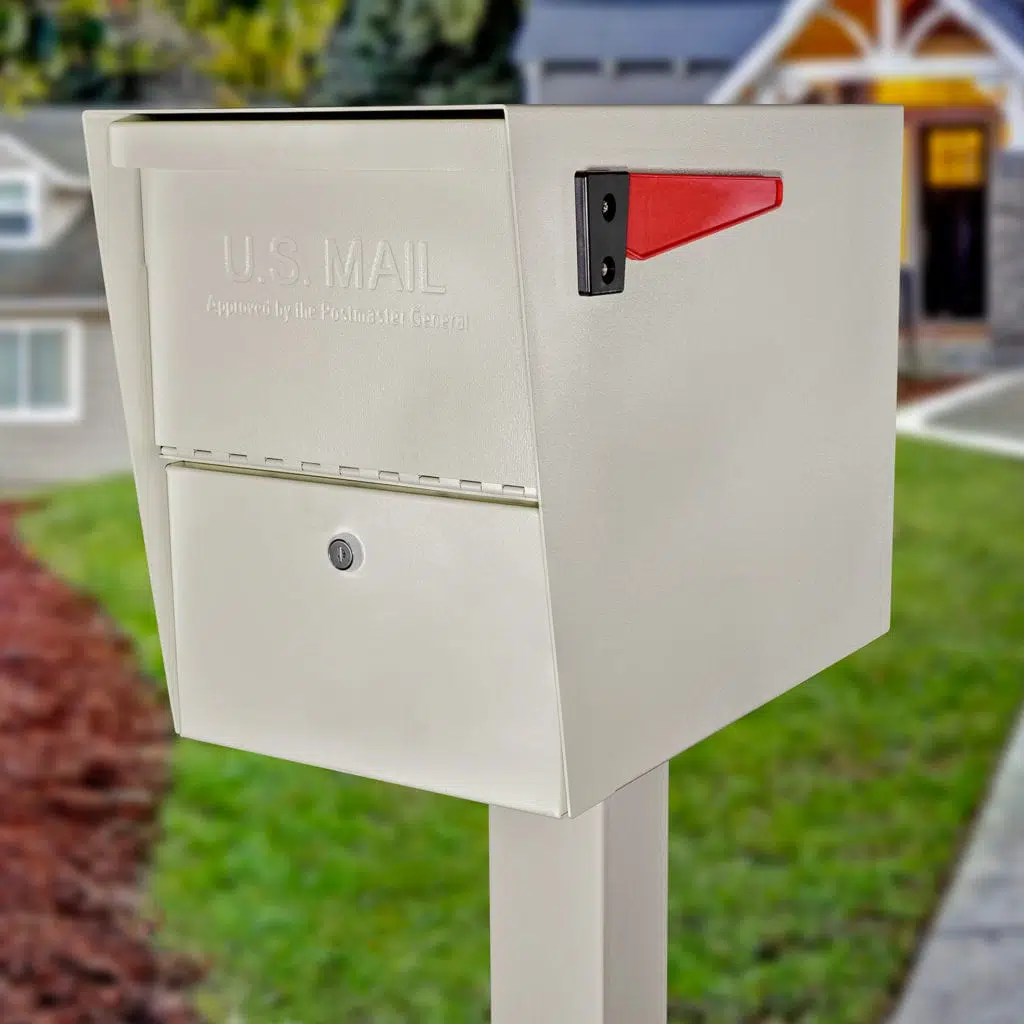 A white mailbox with a red flag on a post in a residential area.